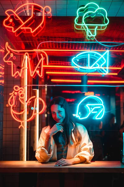 Menina bonita em um café da janela e olha para a câmera — Fotografia de Stock