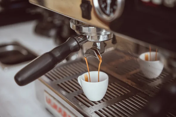 Machine à expresso professionnelle versant du café frais dans une tasse en céramique blanche — Photo