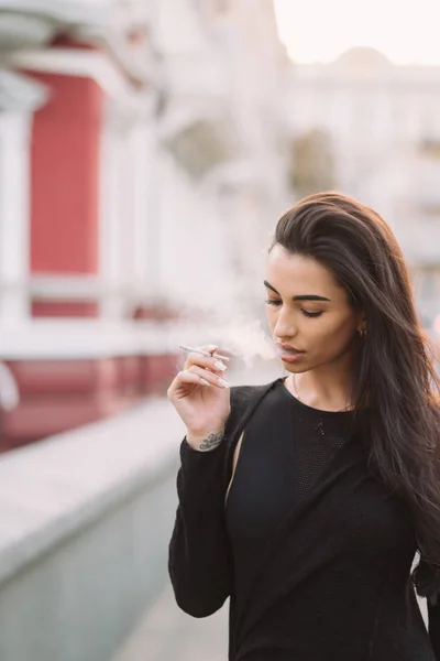 性感的年轻女子在街上抽烟 — 图库照片