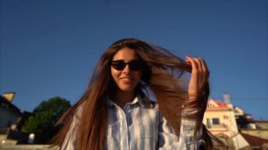 Güzel genç kız sokakta, günbatımı fotoğraf makinesinde poz