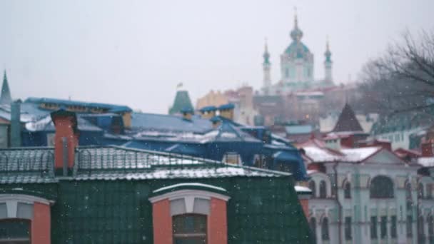 Queda de neve copiosa sobre a cidade com os telhados do edifício e janelas — Vídeo de Stock