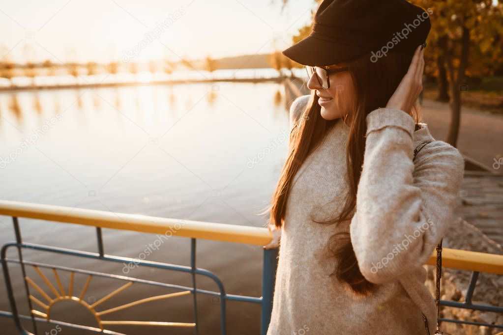 young girl stands on the city embankment by the lake