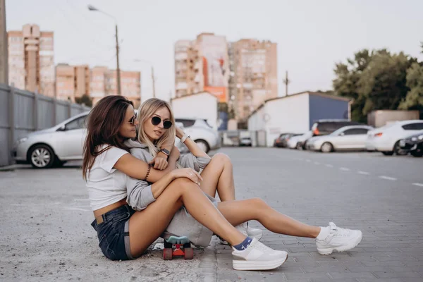 Dos chicas jóvenes y sexys están sentadas en el suelo — Foto de Stock
