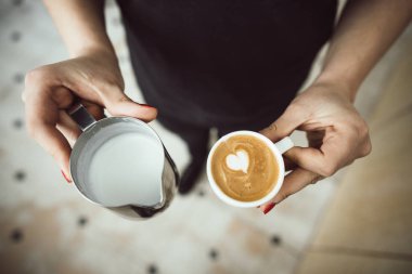 İki bardak süt ve sütlü kahve barista tutar