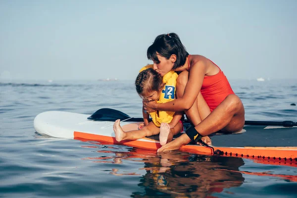 Mère avec sa fille sur une planche à pagaie — Photo