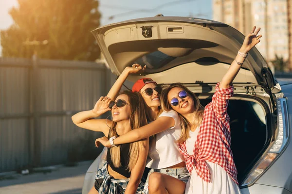 Drie jonge vrouw poseren voor de camera de parkeerplaats. — Stockfoto