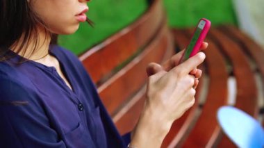 Kadın tezgah ve smartphone kullanarak oturur. Görünümü Kapat