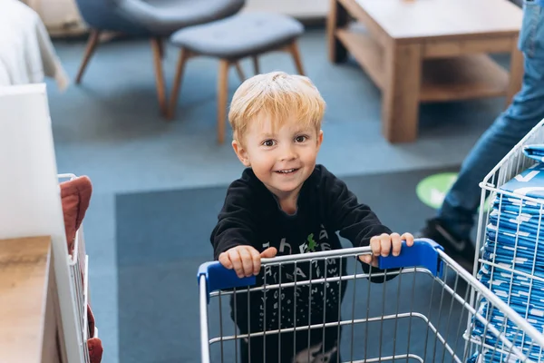 Un ragazzino e un grande carro al supermercato — Foto Stock