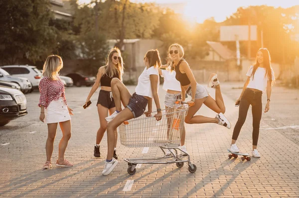 Les jeunes femmes avec un chariot de supermarché s'amusent — Photo