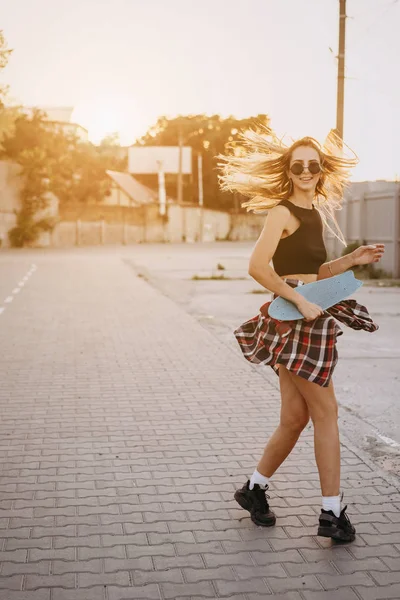 Jovem com um skate em um parque de estacionamento . — Fotografia de Stock