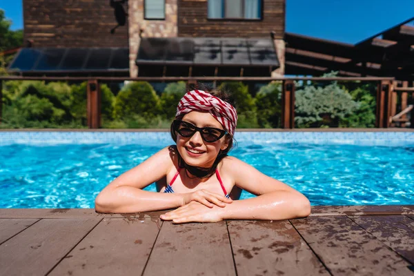 Chica adolescente en una piscina lado mirando a la cámara —  Fotos de Stock