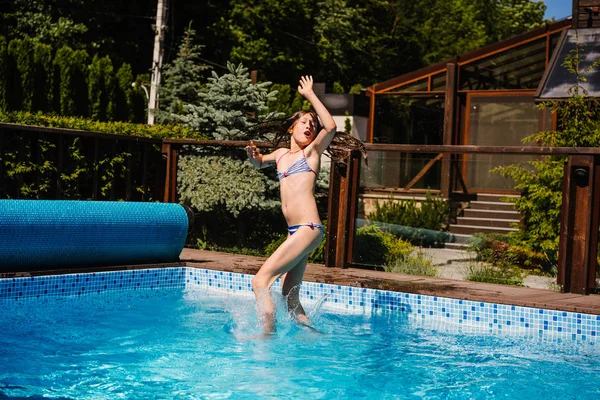 Chica feliz saltando en la piscina —  Fotos de Stock