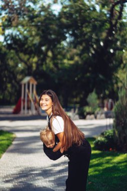 Güzel genç anne yandan küçük oğlunu tutar