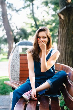 paketi, bir bankta esmer kadın