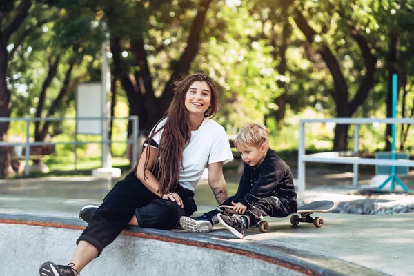 Красива молода хіпстерська мама і маленький син на скейтпарку — стокове фото