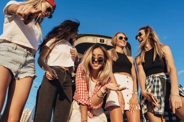 Πέντε νεαρές γυναίκες έχουν διασκέδαση στο χώρο στάθμευσης αυτοκινήτων. — Φωτογραφία Αρχείου