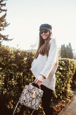 Güzel genç kadın parkta çalıların yakınındaki poz