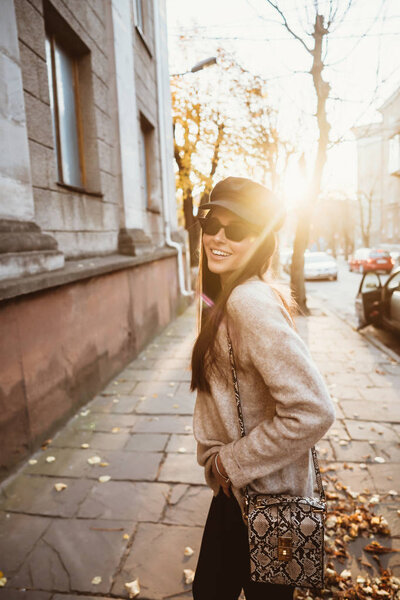 Street portrait of young beautiful fashionable woman wearing stylish clothes walking at the old city