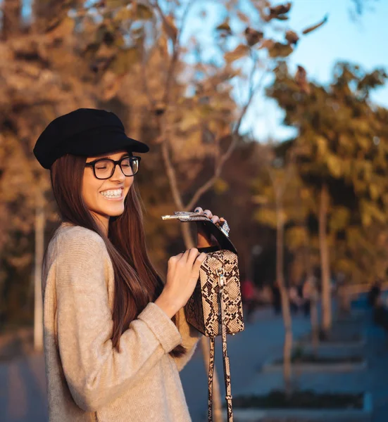 Красивая молодая девушка с сумочкой позирует на камеру — стоковое фото
