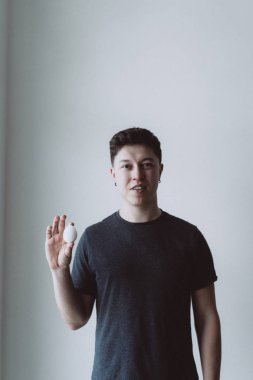 yakışıklı adam gri arka plan üzerinde yumurta holding