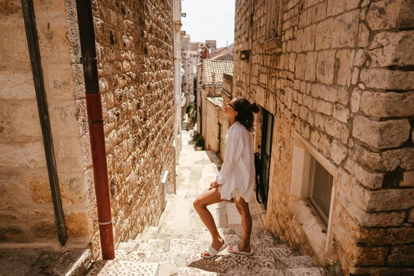 Genç kız güzel yaz gününde eski dar sokaklarında yürüyüş — Stok fotoğraf