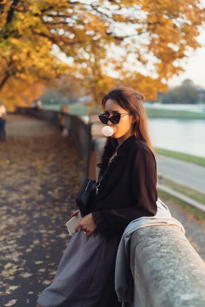 Aantrekkelijke vrouw met behulp van smartphone buiten in het park — Stockfoto