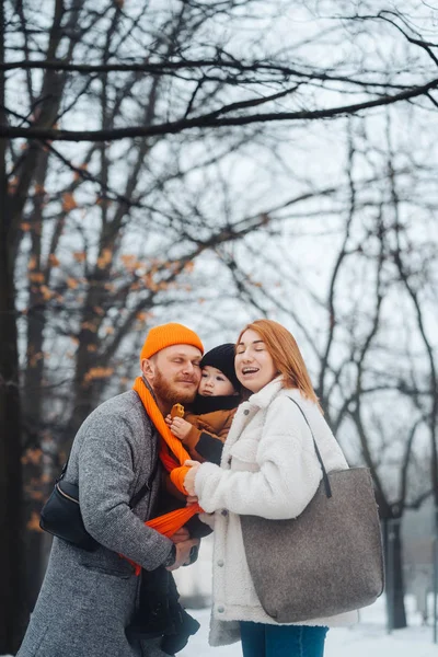 Tatínek a maminka a dítě v sadech v zimě — Stock fotografie