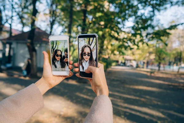 彼女の手の 2 つのスマート フォンの美しい少女を保持します。 — ストック写真