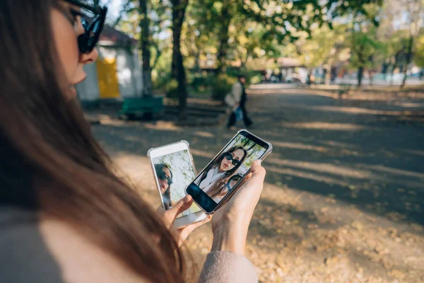 彼女の手の 2 つのスマート フォンの美しい少女を保持します。 — ストック写真