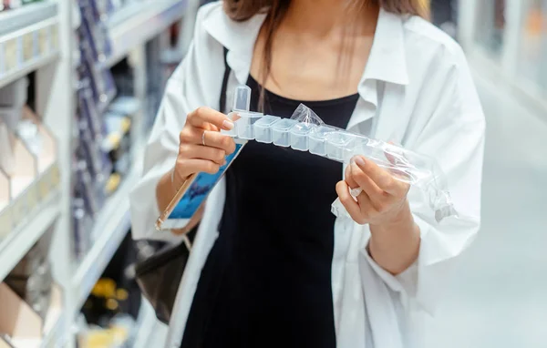 Frau wählt Kunststoffboxen in verschiedenen Farben für die Werkstatt — Stockfoto