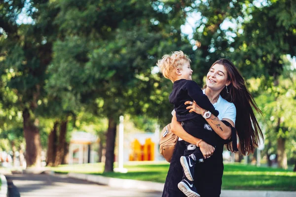 Bella giovane madre tiene per mano il suo piccolo figlio — Foto Stock