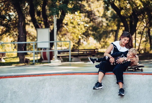 Bella giovane mamma hipster e piccolo figlio allo skatepark — Foto Stock