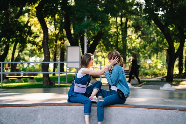 Dwie szczęśliwe młode dziewczyny siedzące w skate parku — Zdjęcie stockowe