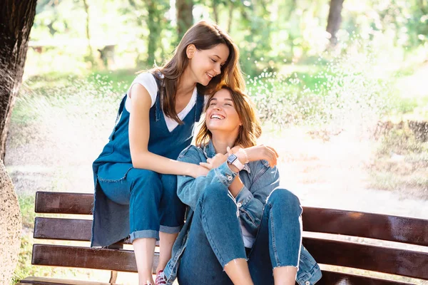 Deux belles jeunes femmes reposant sur un banc — Photo