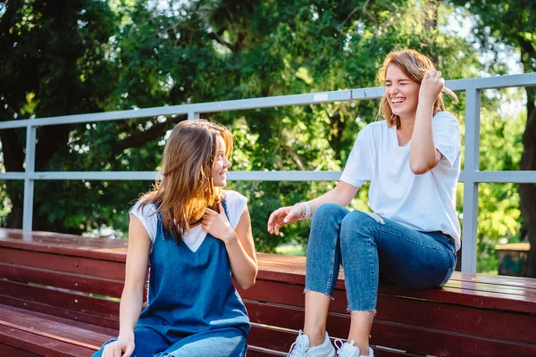 Två vackra unga kvinna vilar på en bänk — Stockfoto