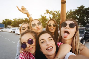 Altı güzel kız kameraya bakıyor ve selfie çekiyor.