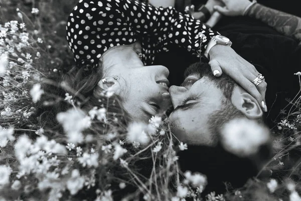 Giovane coppia si trova sul campo con margherite . — Foto Stock