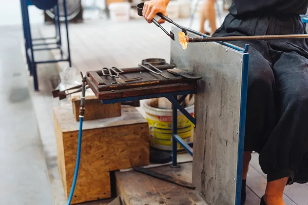 Cam üfleyen bir öğrenci camdan çiçek yapmaya çalışır.