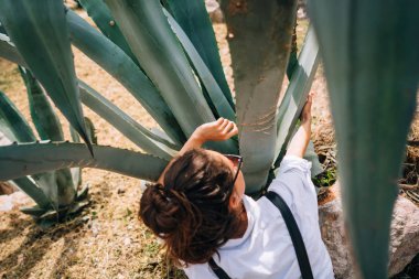 Büyük aloe vera yaprakları poz mutlu güzel kızın arkadan görünüm