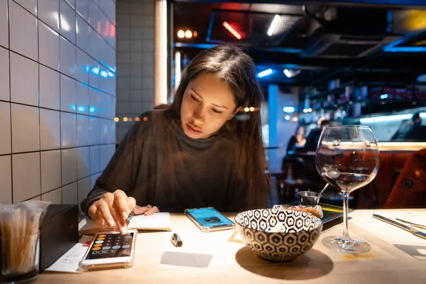 Woman works at a cafe in the evening — Stock Photo, Image