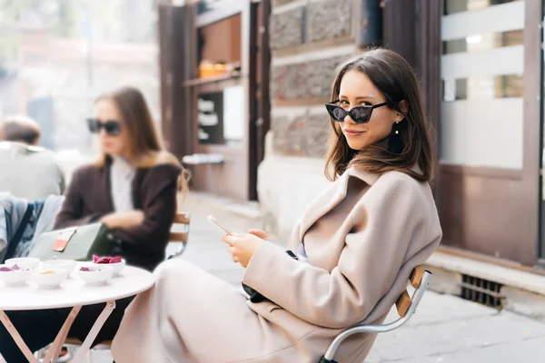 ผู้หญิงสาวที่มีสไตล์ โพสในร้านกาแฟถนนสมัยใหม่ . — ภาพถ่ายสต็อก