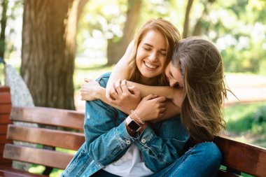 İki güzel genç kadın bir bankta dinleniyor.