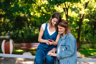 Smartphone vasıl belgili tanımlık bohça iki kadın kız bakmak