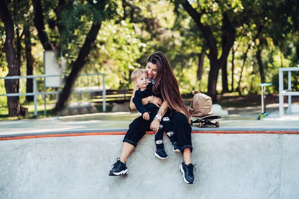 Bella giovane mamma hipster e piccolo figlio allo skatepark — Foto Stock