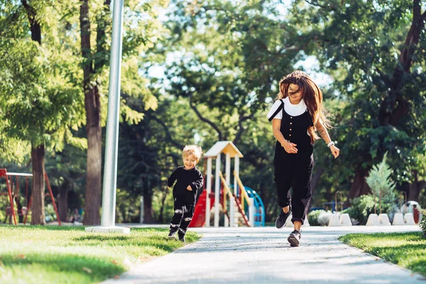 Mère et petit fils marchent dans le parc — Photo