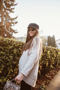 Güzel genç kadın parkta çalıların yakınındaki poz