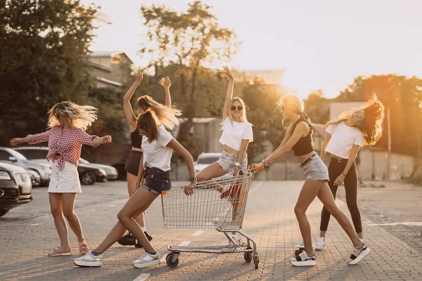 Mladé ženy s vozíkem supermarketu bavit — Stock fotografie