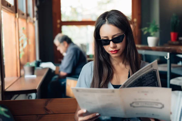 선글라스에 매력적인 여자는 레스토랑에 앉아. — 스톡 사진