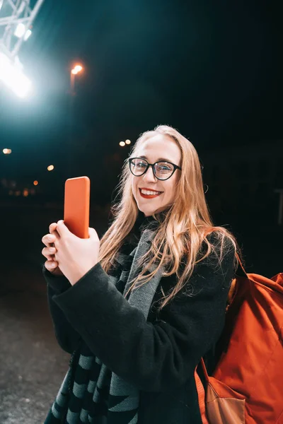 거리에서 밤에 스마트폰으로 금발 여자. — 스톡 사진