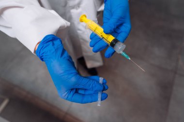 Lastik eldiven elinde bir tek kullanımlık tıbbi şırınga uyuşturucu ile tutun